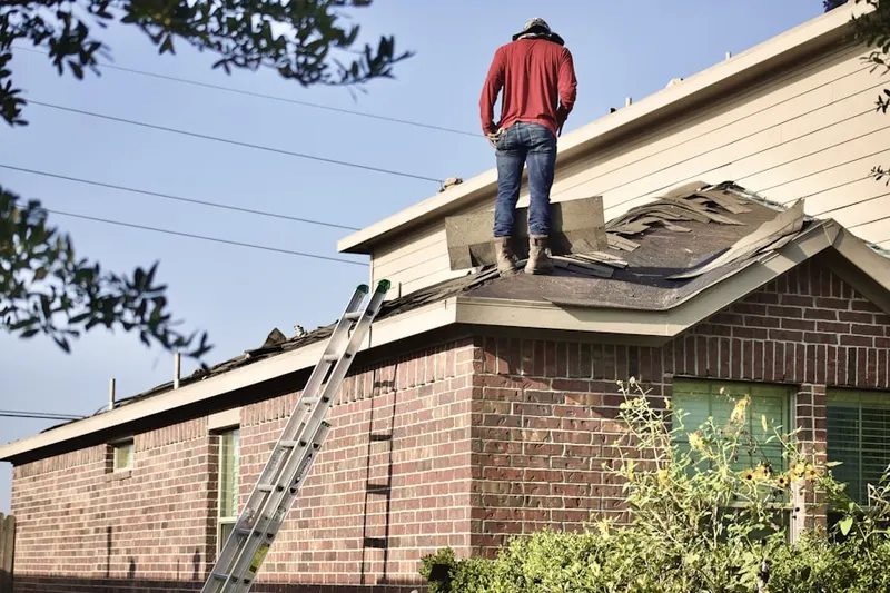 Professional roofer working on a residential roof in Snug Harbor